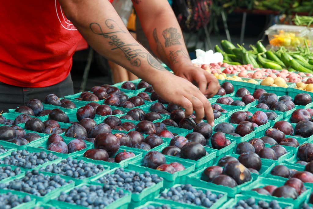 Farmer setting up stand of local produce 