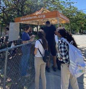 Neighors and students mingle at a FRESHFARM school farm stand. 