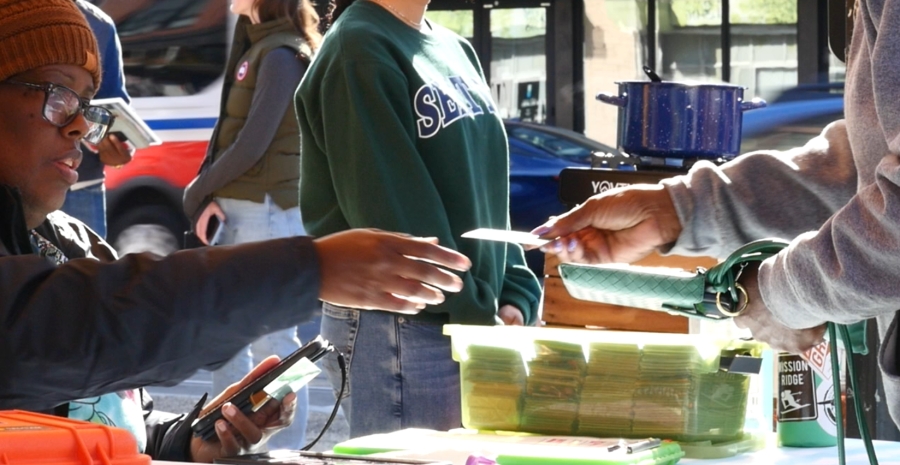 Shopper using the digital Produce Plus card at a farmers market