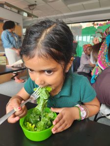 A student enjoys salad in the FoodPrints classroom